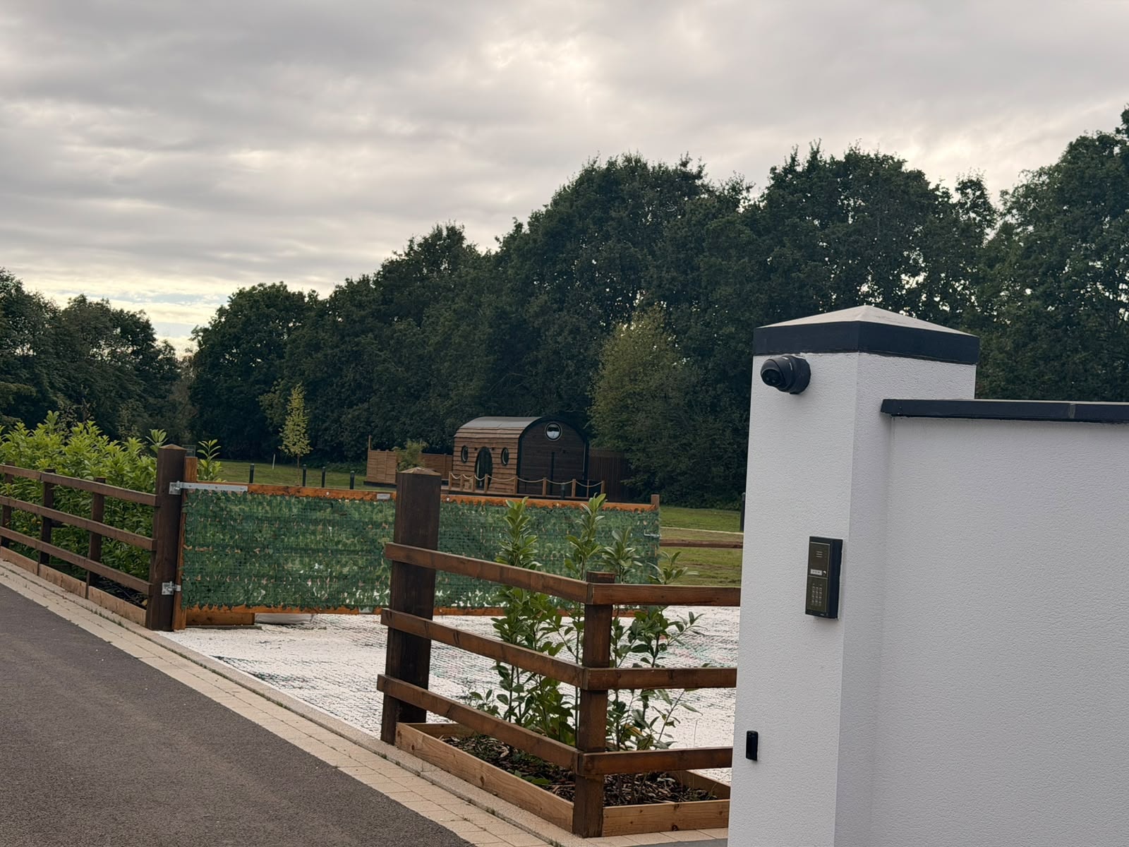 Elmtree Cabins property entrance with wooden fencing and the cabin visible beyond